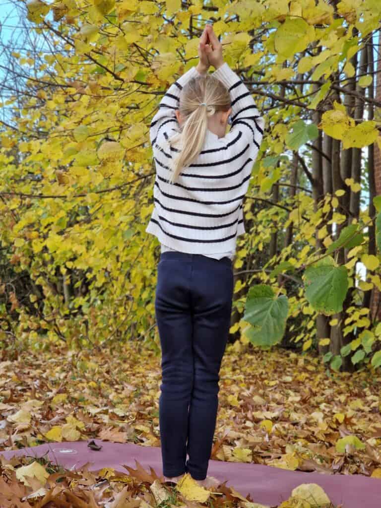 Mandys Tochter in einer Yogapose beim Kinderyoga und Familienyoga in herbstlicher Umgebung